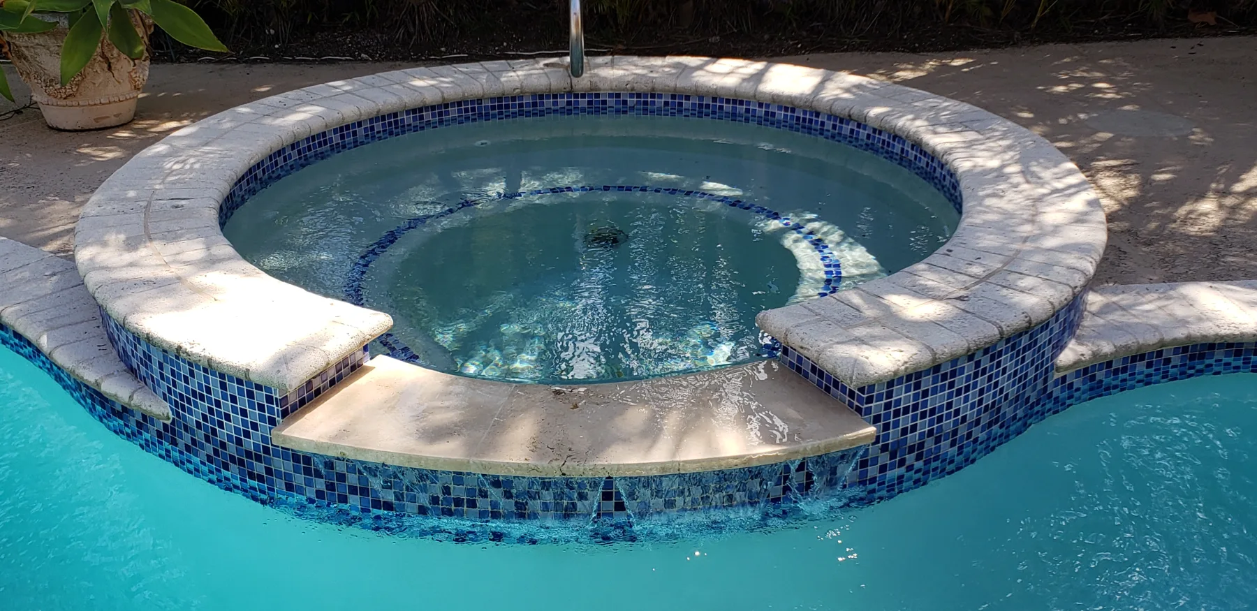 Close view of the raised spa and tile around a swimming pool