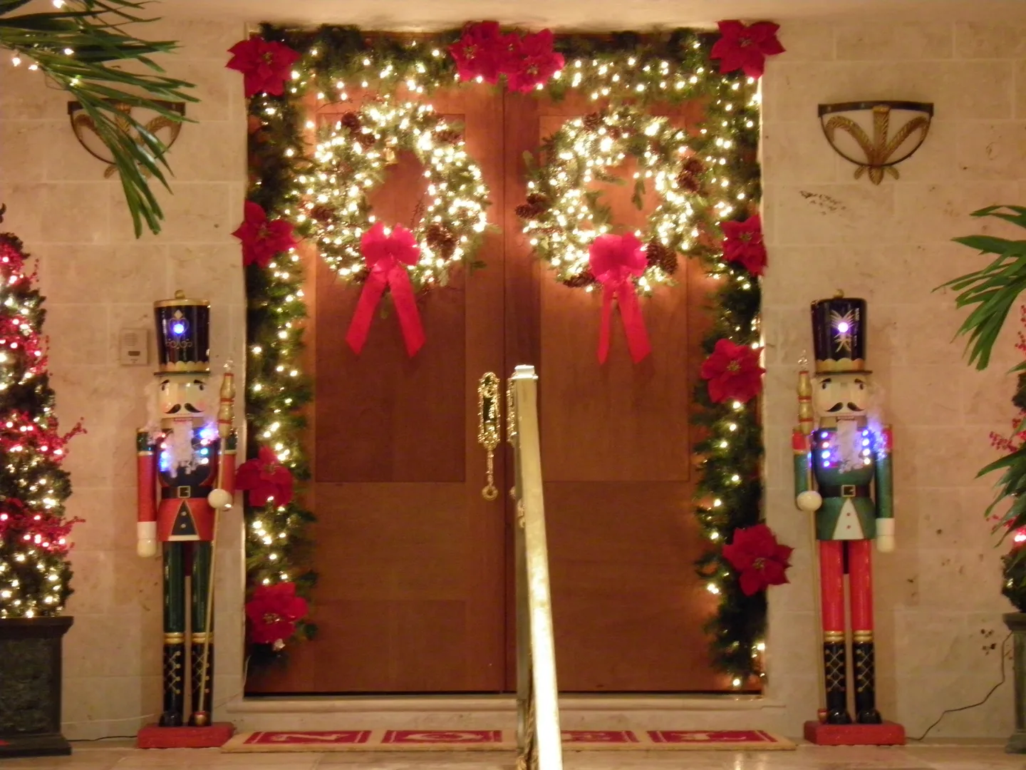 Front doorway decorated with illuminated garlands and red bows