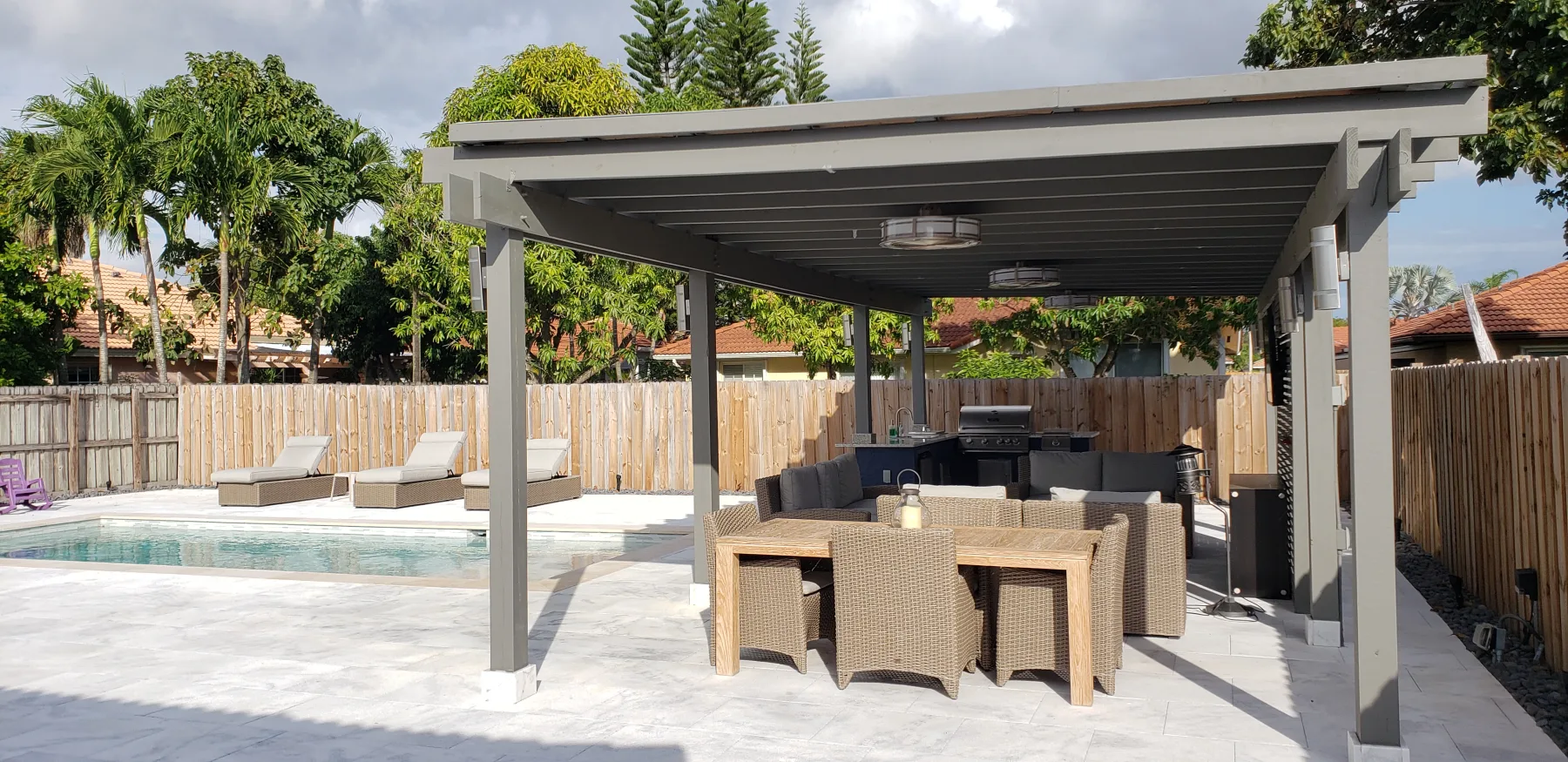 Shaded patio dining area beside a swimming pool