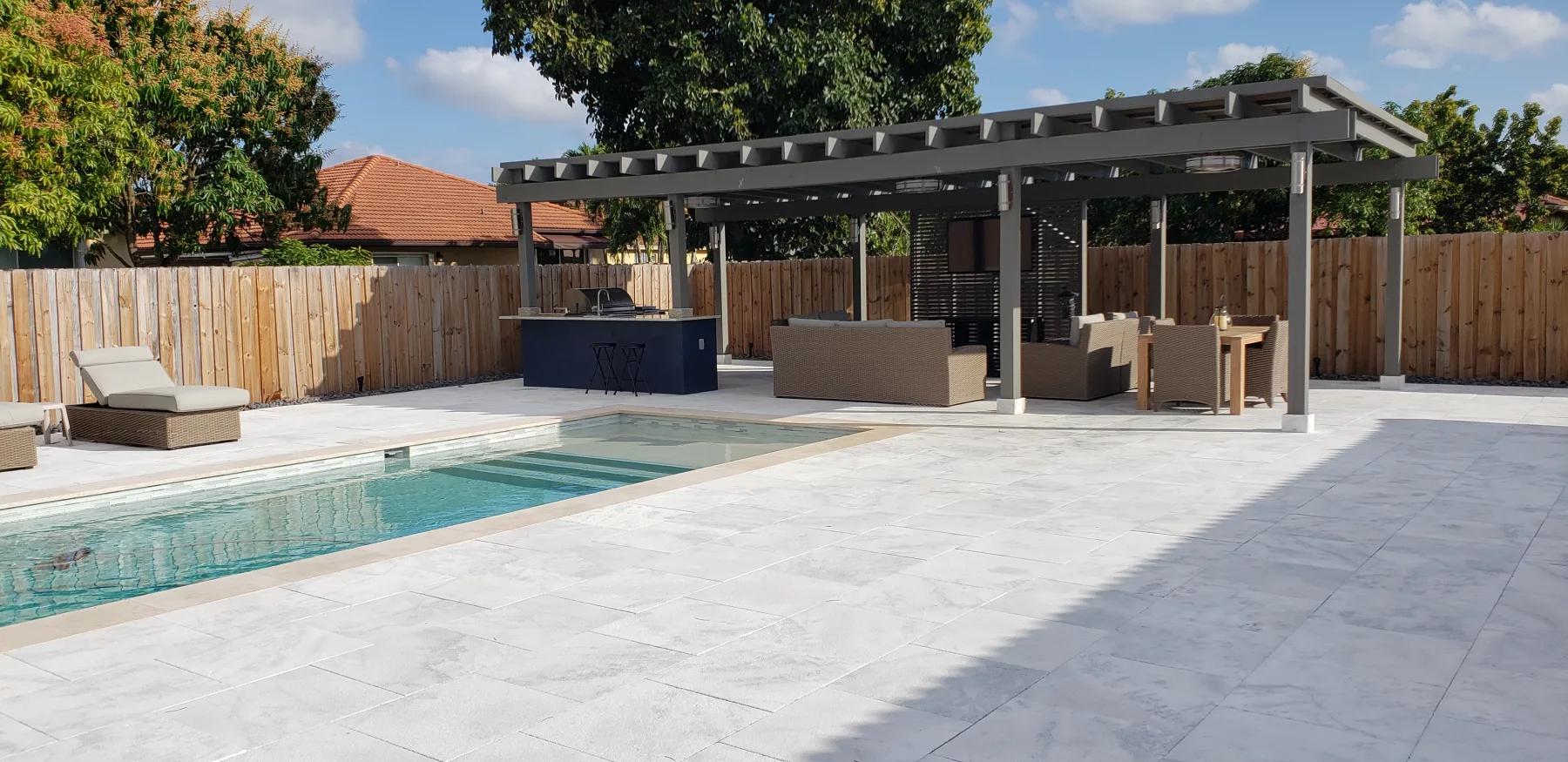 Poolside lounge seating and covered outdoor kitchen