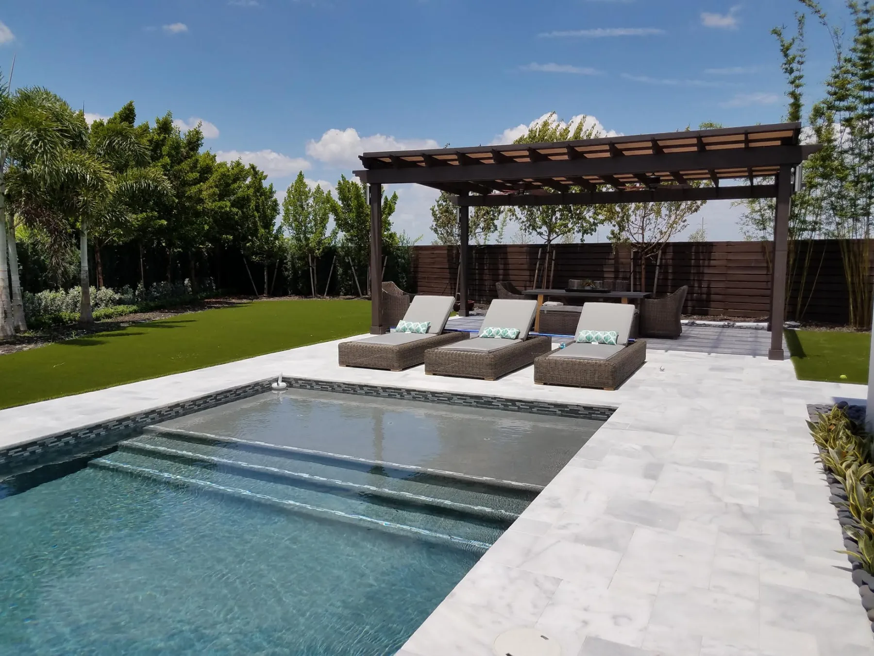 Pool and pergola viewed across the lawn and patio